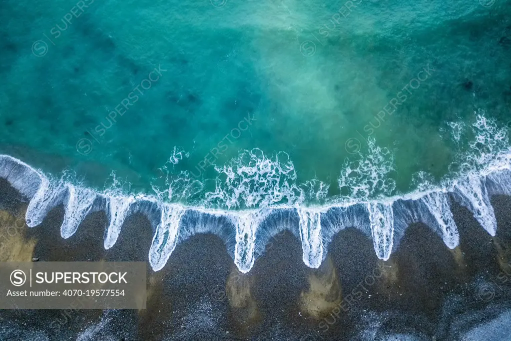 Aerial of patterns of receding waves, Playa del Silencio, Asturias, Spain. April 2018