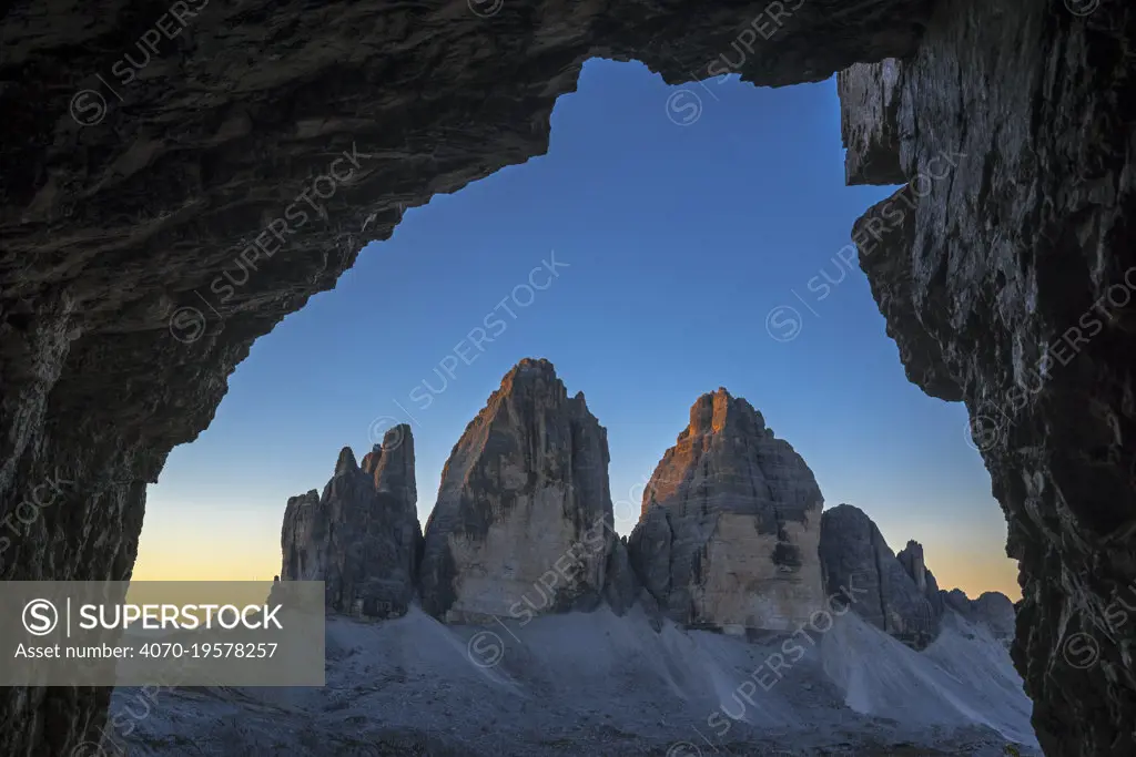 Tre Cime di Lavaredo / Drei Zinnen, three distinctive mountain peaks in the Sexten Dolomites seen from WW1 cave shelter, South Tyrol, Italy, October 2019