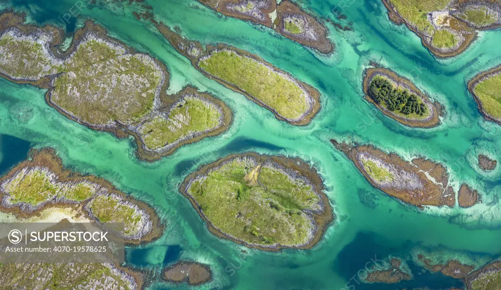 Aerial view of sporadically inhabited islands, islets and skerries in a wide coastal plain. Husvaer, Helgeland Archipelago, Norway. July.