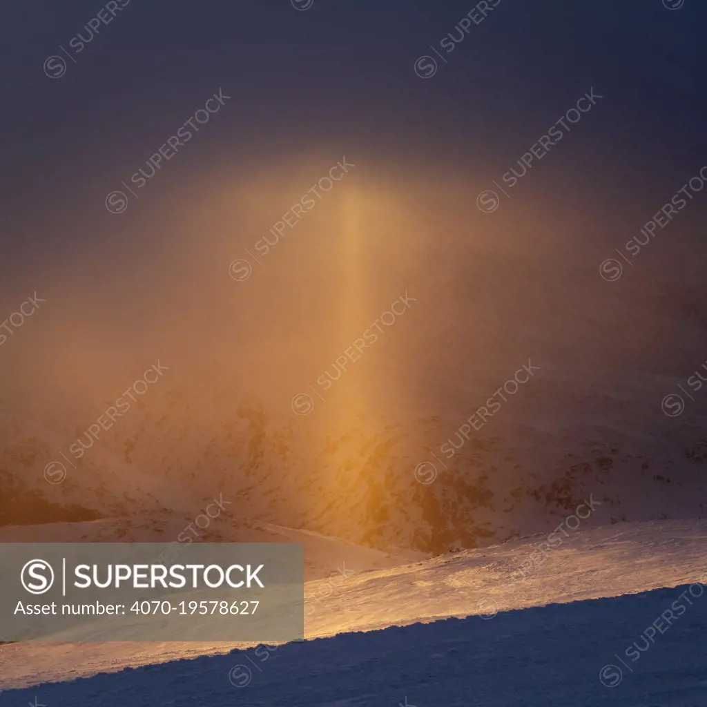 Sun pillar (optical phenomenon) that appears against the setting sun in light snow. Sognefjellet, Norway. April.