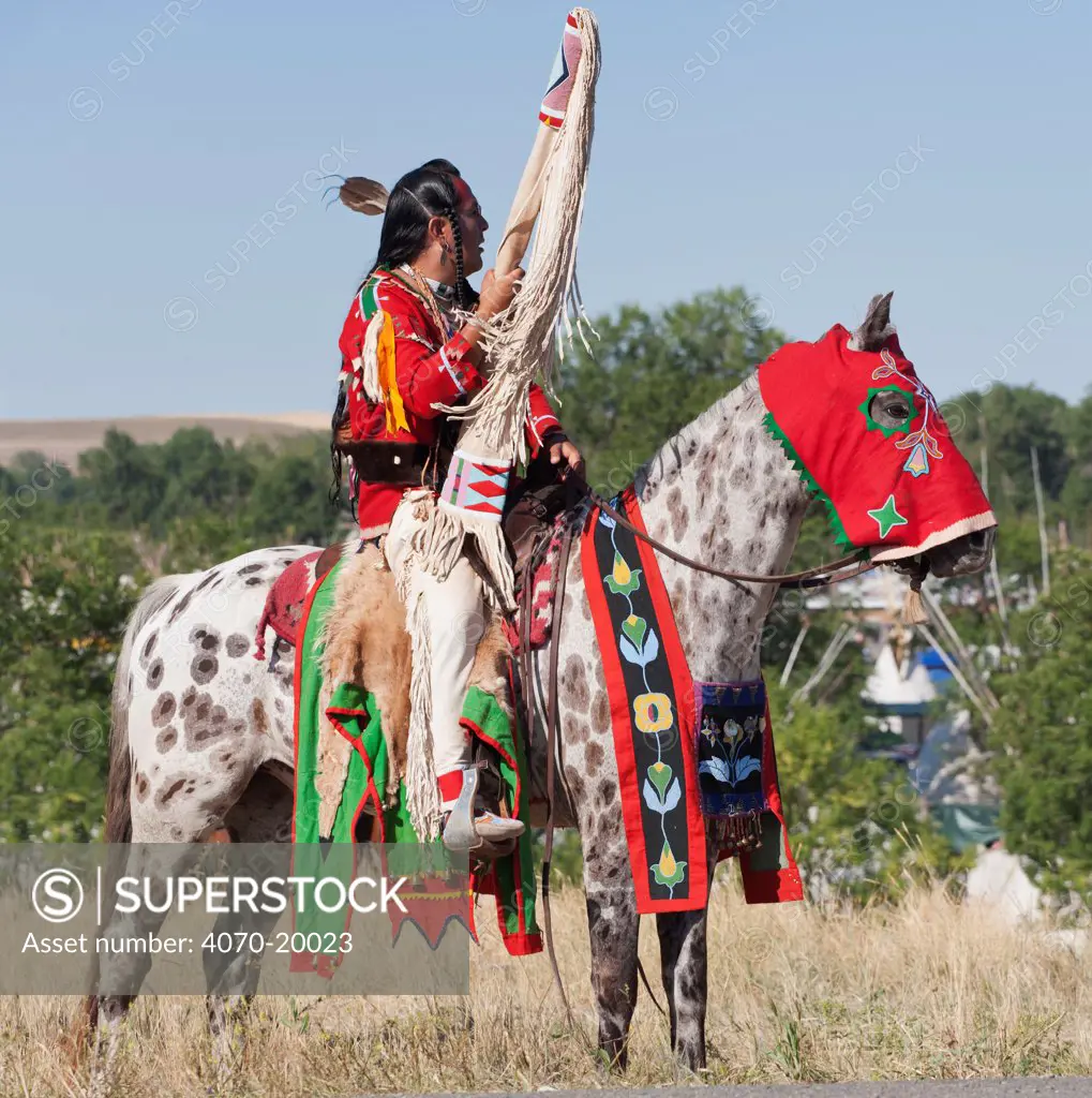 A traditionally dressed Crow Indian man rides an appaloosa horse during the parade, at the annual Indian Crow Fair, at Crow Agency, near Billings, Montana, USA, August 2011