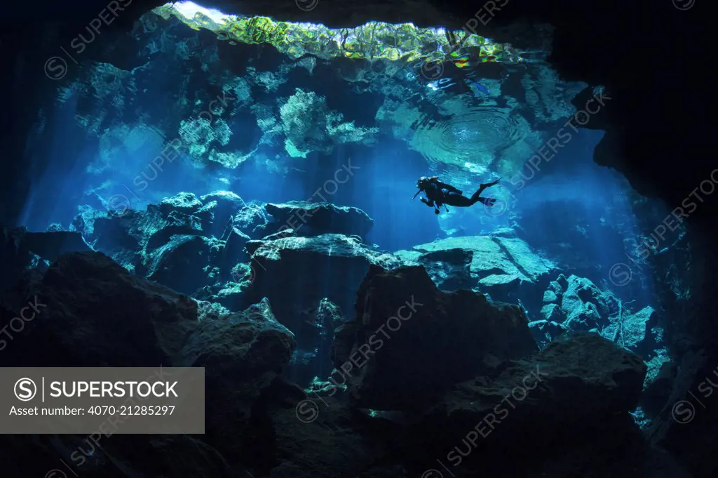 A diver explores Chac Mool Cenote (or sinkhole) Puerto Aventuras, Quintana Roo, Mexico.  No model release available.