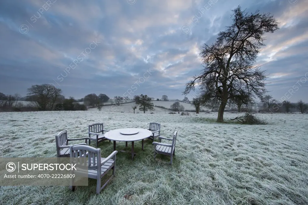 Garden table at dawn covered in frost, Shropshire, England, December 2014.