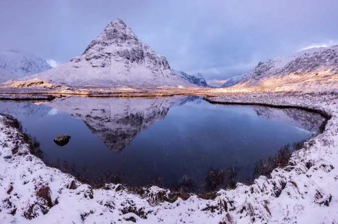 Buachaille Etive Beag reflected in Lochan na Fola after snowfall, early morning light, Glencoe, Scotland, UK. February 2017.