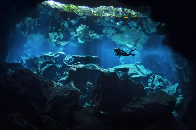 A diver explores Chac Mool Cenote (or sinkhole) Puerto Aventuras, Quintana Roo, Mexico.  No model release available.