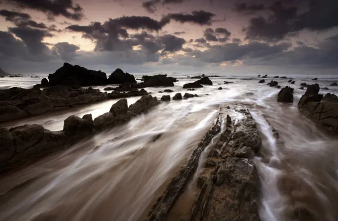 Waves rushing over rocks on Barrika Beach, Bilbao, Basque Country, Spain