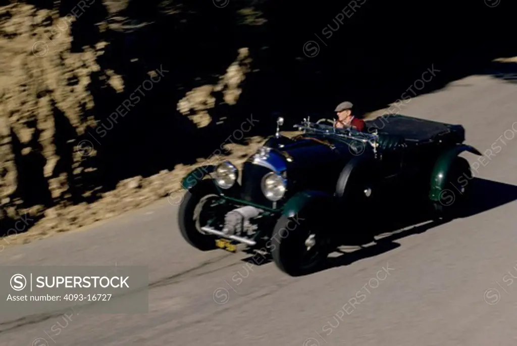 1929 Bentley 4.5 liter Touring Car front 3/4 action Phil Hill. Once owned by the legendary racer Phil Hill who's driving it in this photo. Although W. O. Bentley despised forced induction, his Bentley Boys, and especially Henry Tim Birkin, wanted to supercharge the engine for more power. When the company ran out of money in 1925, millionaire Bentley Boy, Woolf Barnato bought the company, and in 1929 the first supercharged 'Blower' Bentley was built at Sir Henry Birkin's engineering works in Welw