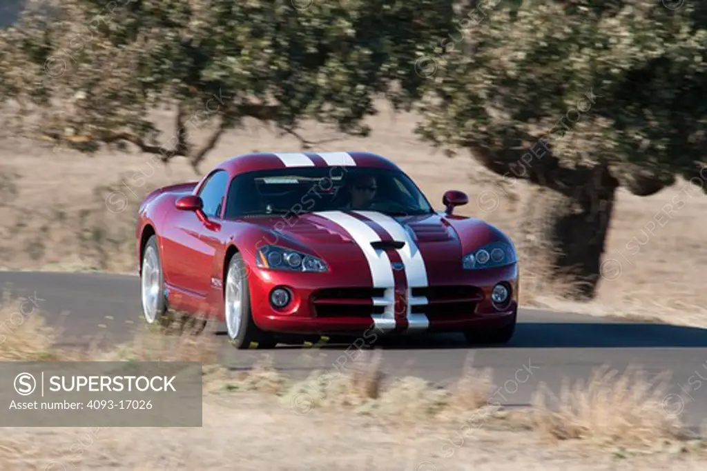 2009 Dodge Viper SRT-10 srt10 in Venom Red Metallic with white racing stripes driving fast through the hils of central California