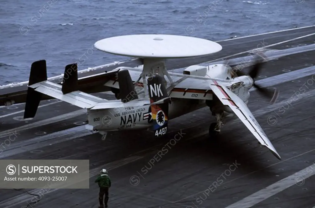 US Navy Grumman E-2C Hawkeye AWACS, airborne radar aircraft folds its wings after trapping / taking a trap on the aircraft carrier USS Abraham Lincoln off the California coast