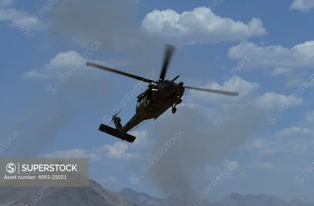 US Air Force Sikorsky MH-60 Blackhawk special operations helicopter kicks up dust while landing in the desert on a combat search and rescue mission