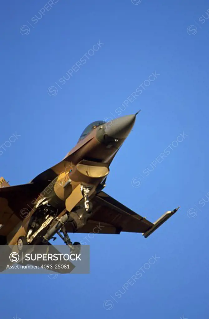 USAF Lockheed F-16 Fighting Falcon (Viper) of the 64th Aggressor Squadron in Lizard camouflage of browns and greens  on final approach to Nellis AFB  the squadrons home.