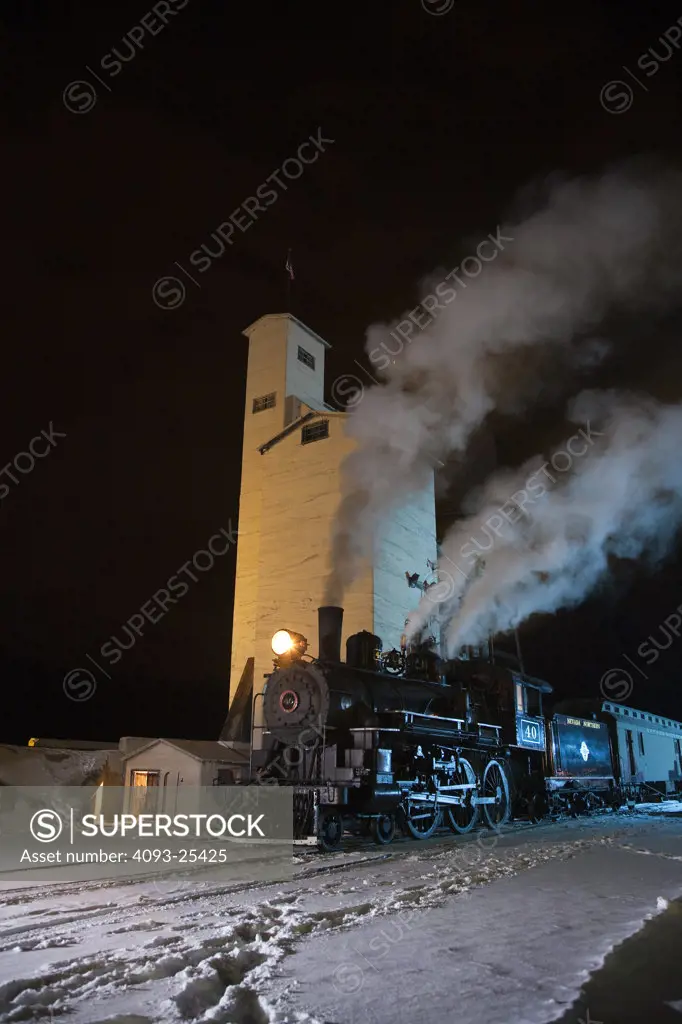 1910 4-6-0 engine Steam locomotive number 40 in front of a coaling tower and water tower at night view