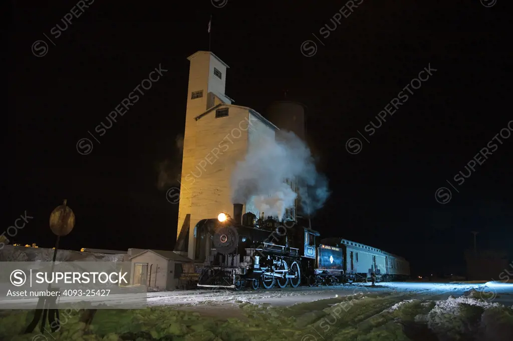 1910 4-6-0 engine Steam locomotive number 40 in front of a coaling tower and water tower at night view