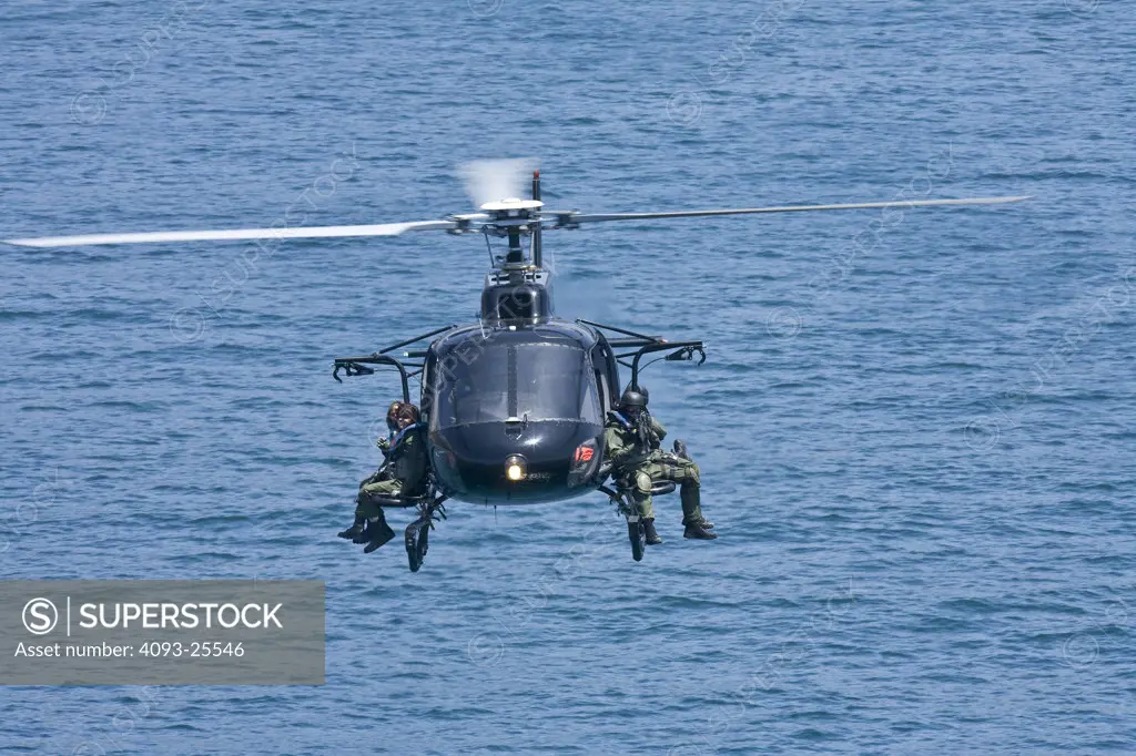 Eurocopter AS350 Ecureuil A-Star Helicopter flying over the Pacific Ocean near Malibu, CA during a Fast Rope type military operation.