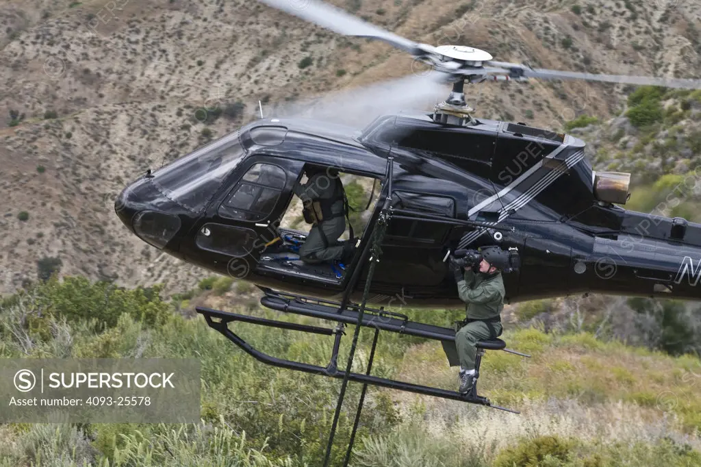 Eurocopter AS350 Ecureuil A-Star Helicopter flying over the hills of Malibu, CA during a Fast Rope type military operation.