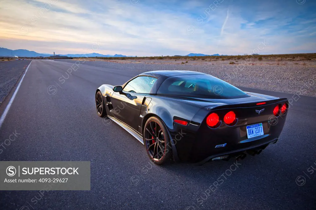 Rear 3/4 static of a black 2013 Chevrolet Corvette ZR-1 on a rural desert road.