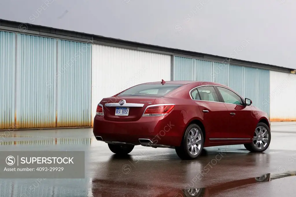 2010 Buick LaCrosse parked next to a row of hangers at an airport, rear 3/4 static view