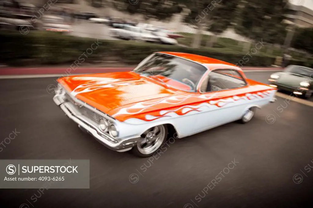 1961 Chevrolet Impala Bubble Top with flame paint job, cruising along road, front 3/4