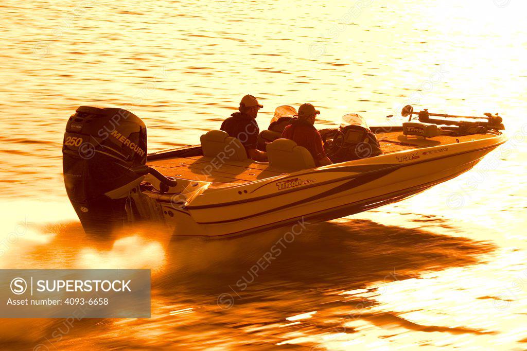 high angle bass boat yellow outboard motor wake spray - SuperStock