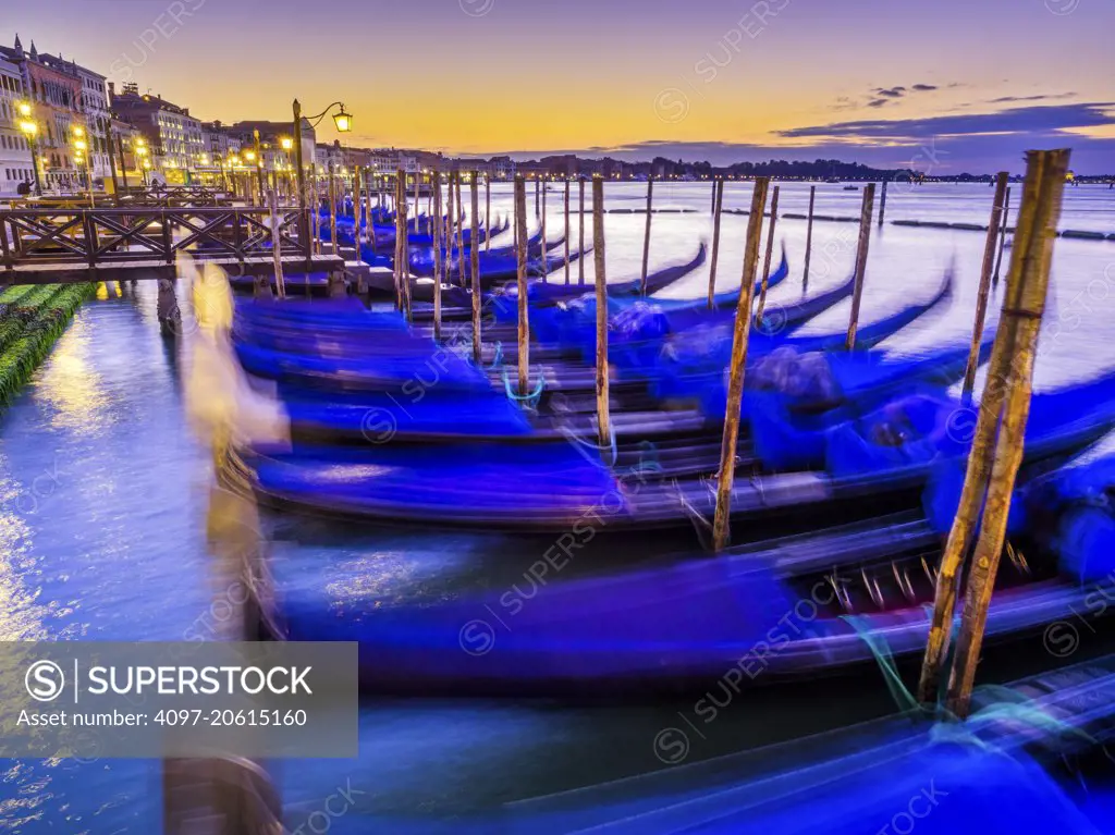 Godolas moored at sunrise by San Marco square in Venice, Italy