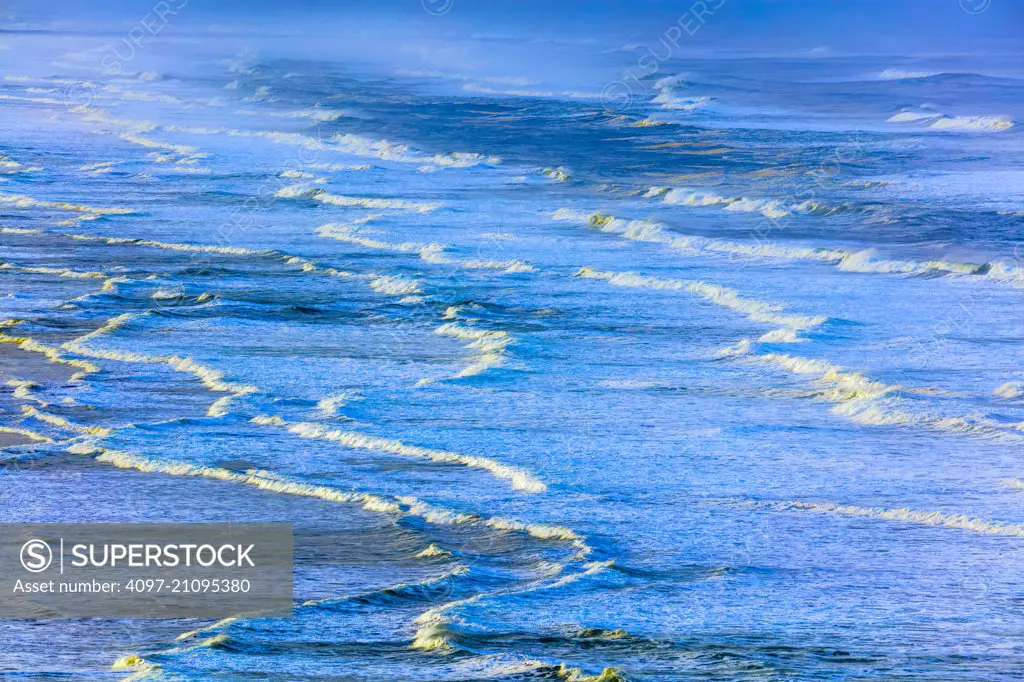 Surf rolling onto expansive sand beach on the Oregon Coast