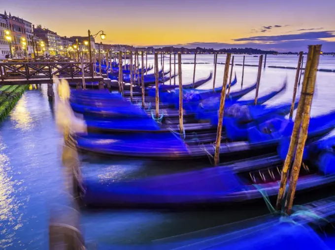 Godolas moored at sunrise by San Marco square in Venice, Italy