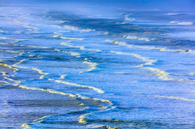 Surf rolling onto expansive sand beach on the Oregon Coast