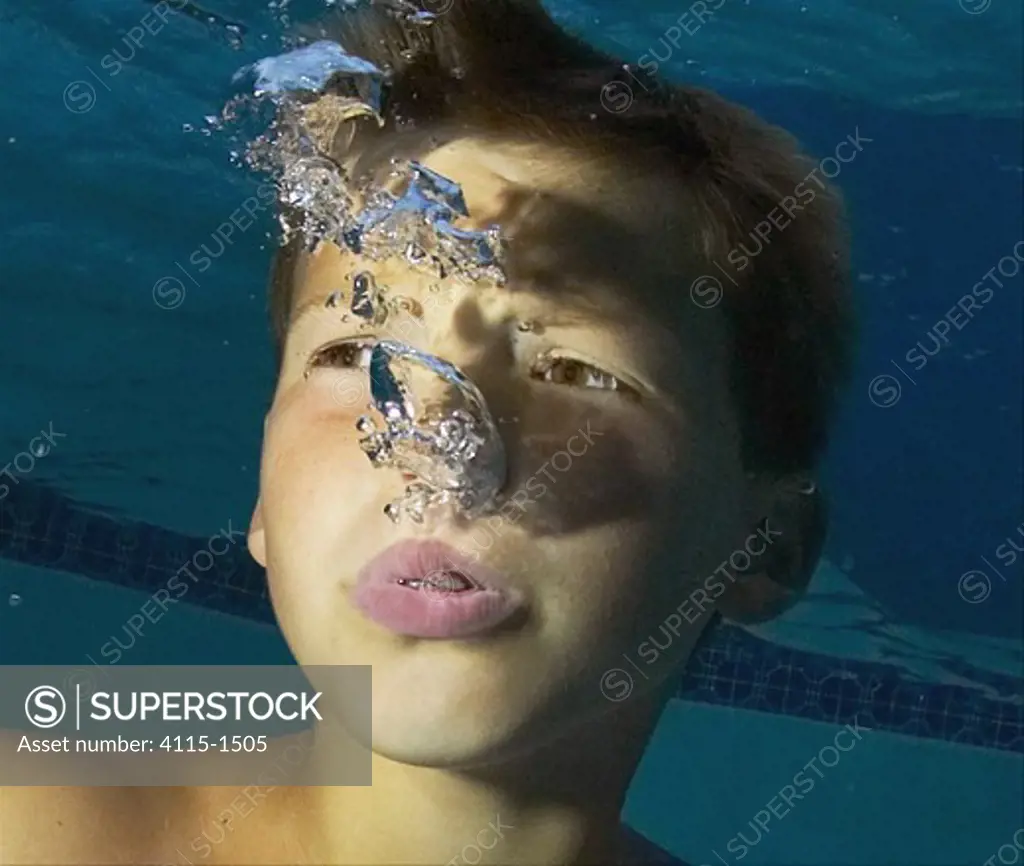 Boy blowing bubbles underwater.