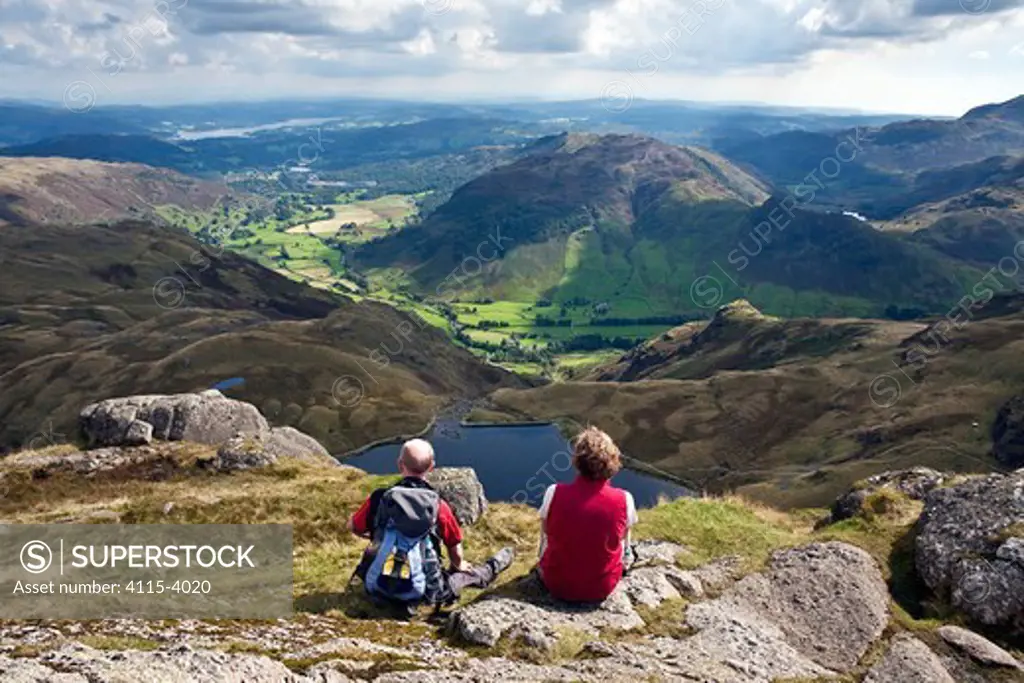 Couple looking out over Stickle Tarn and Great Langdale valley, from Pavey Ark. Lake District, Cumbria, England. September 2010.