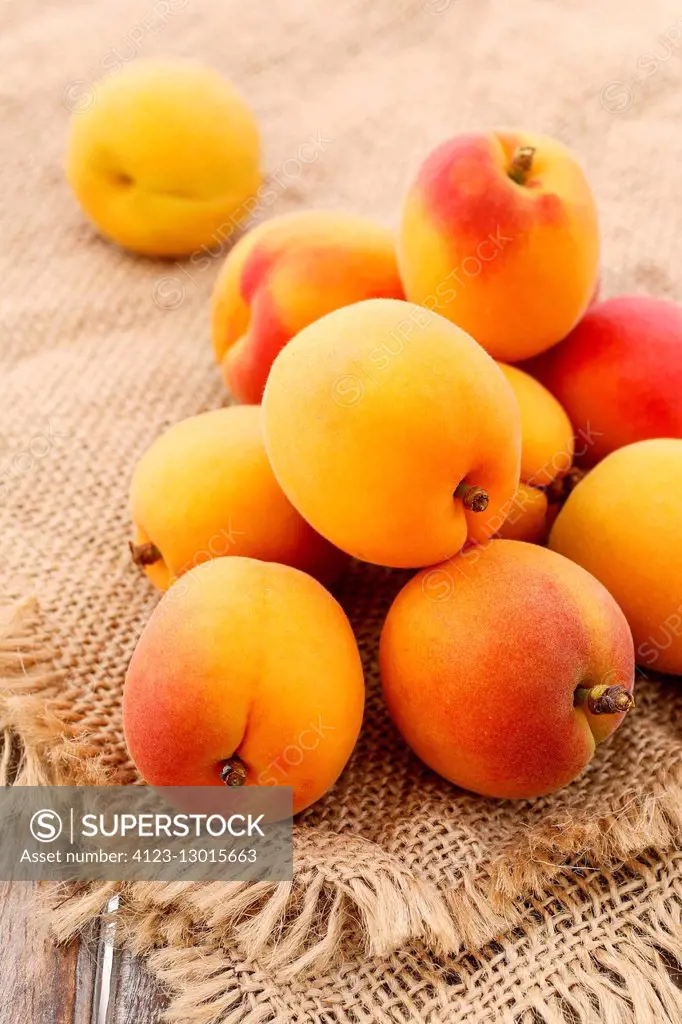 Stack of apricots on jute background. Healthy food