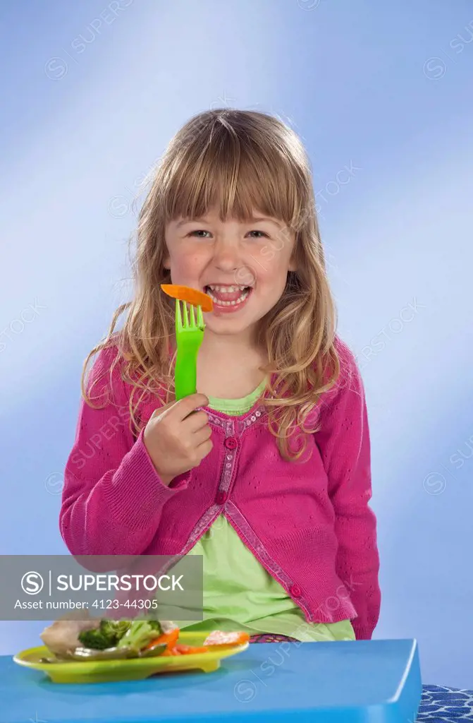 Six year old girl eating healthy dinner.