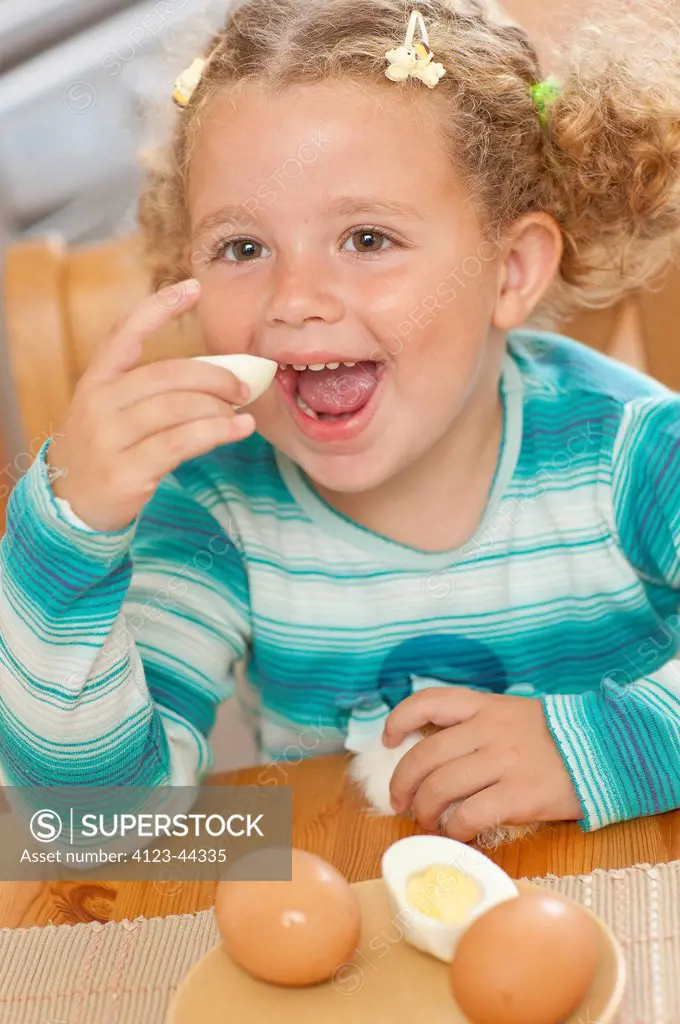 Adorable girl eating boiled eggs.