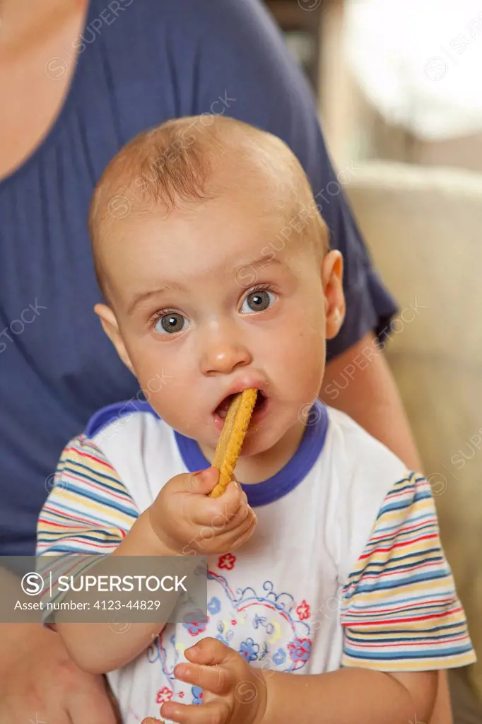 Adorable baby girl eating cookies.