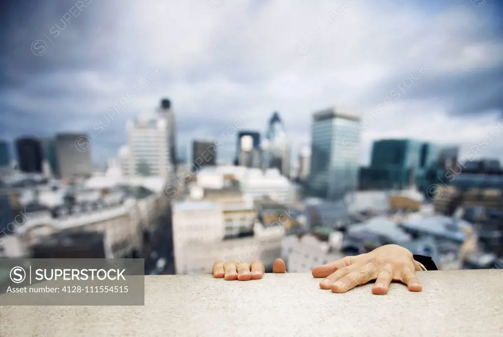 Man hanging on to building ledge