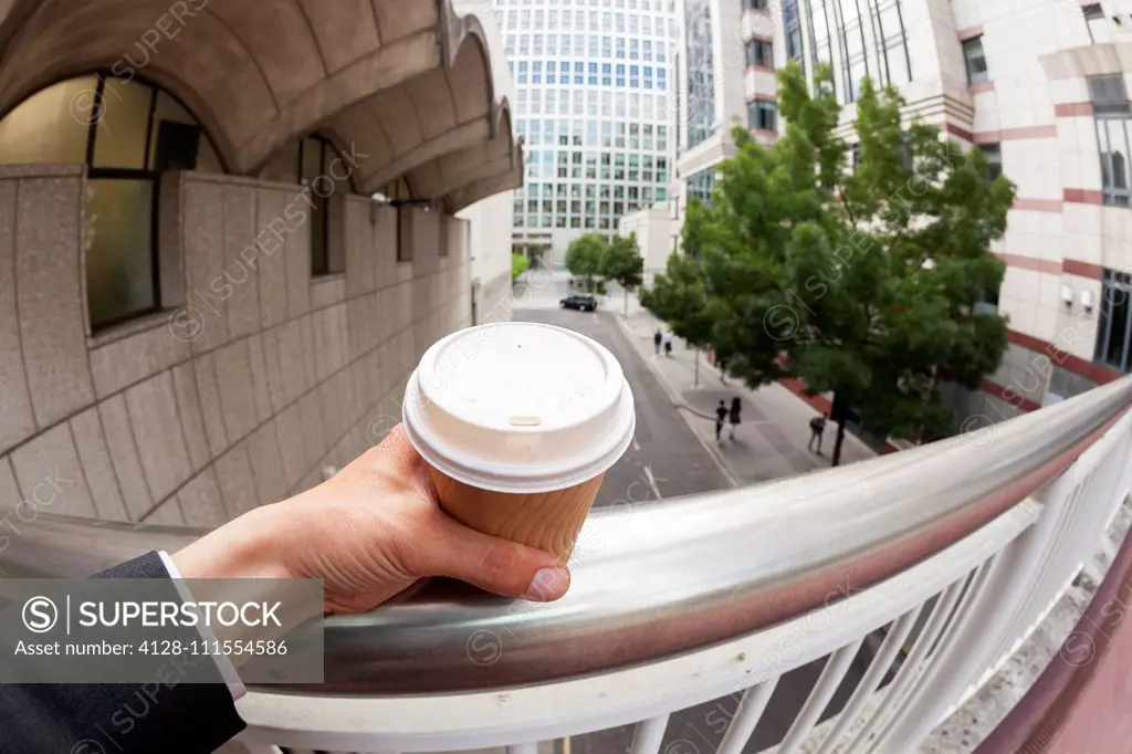 Businessman holding disposable coffee cup