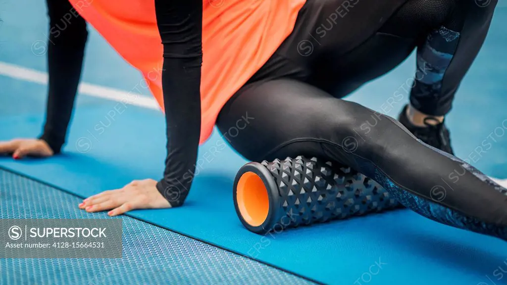 Female athlete using foam roller