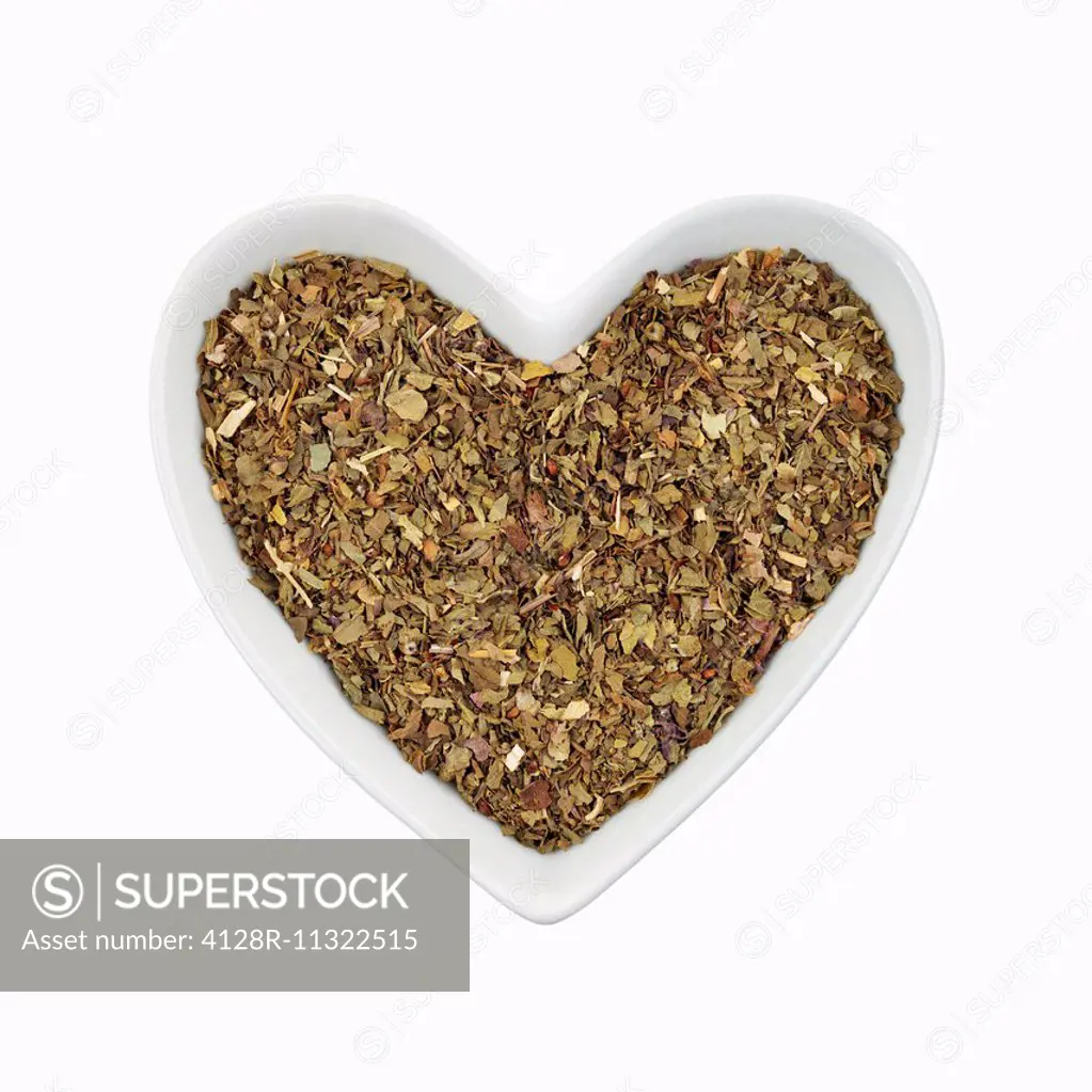 Basil herb in a heart shaped dish. SuperStock