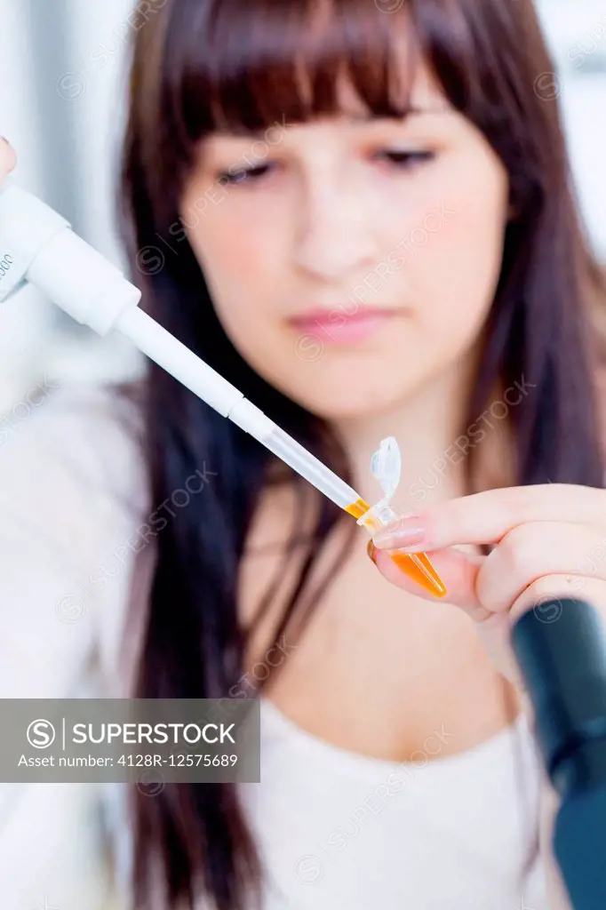 Female laboratory assistant using a pipette.