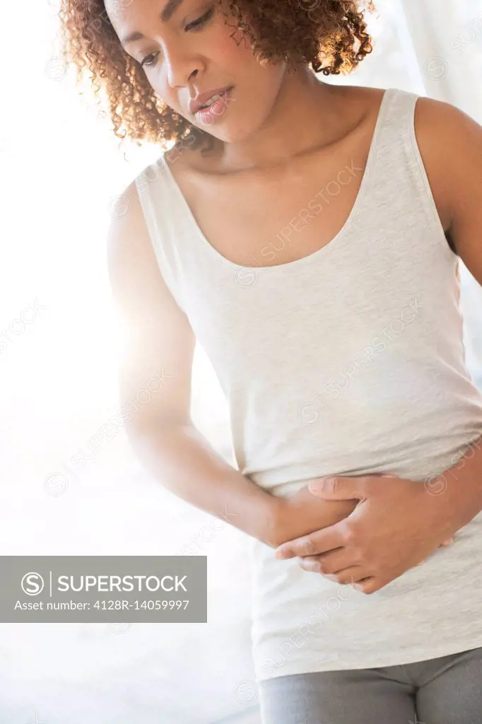 Mid adult woman holding stomach