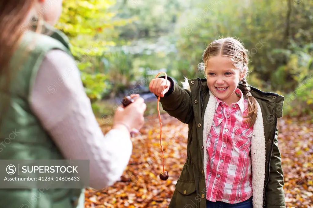 Two girls playing conkers