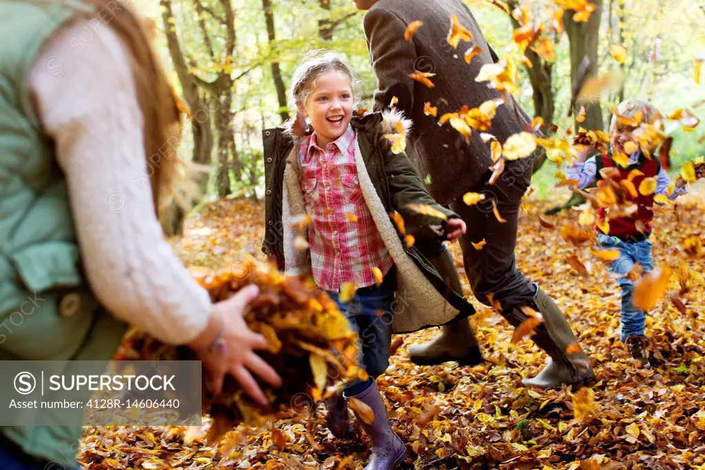 Family playing in Autumn leaves