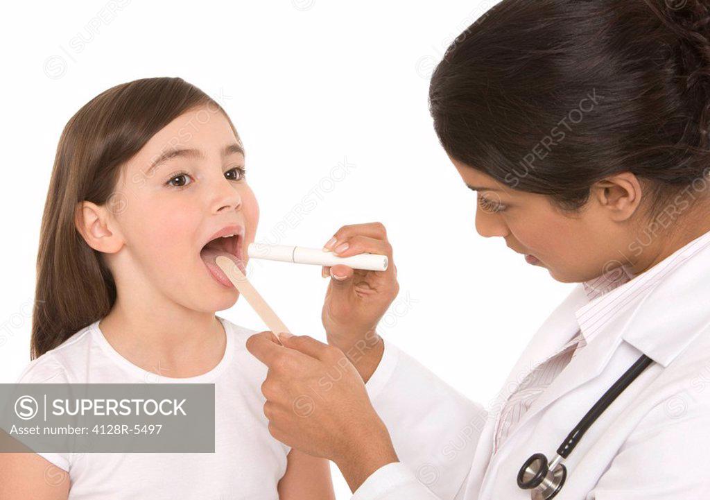 Throat examination. Paediatrician using a tongue depressor and a