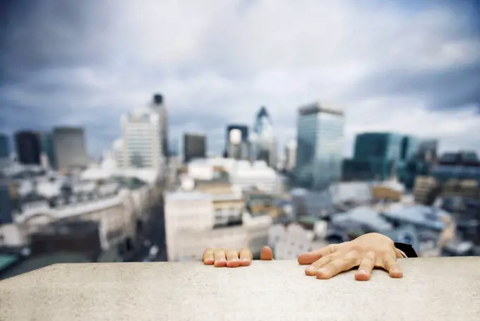 Man hanging on to building ledge