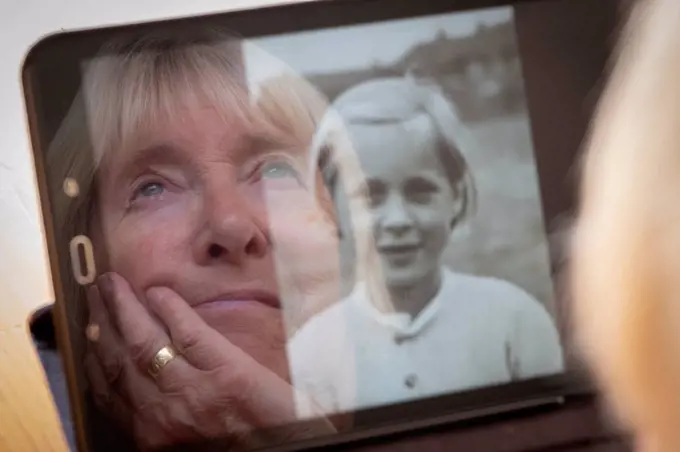 Senior woman looking at her younger self