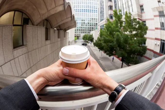 Businessman holding disposable coffee cup