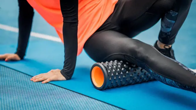 Female athlete using foam roller