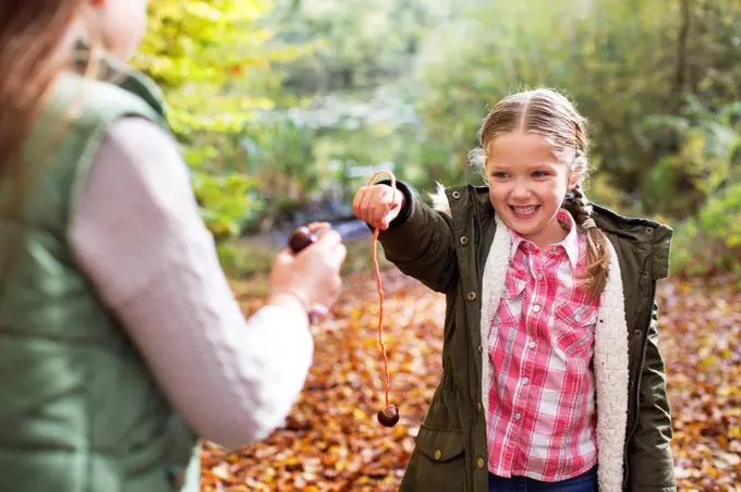 Two girls playing conkers