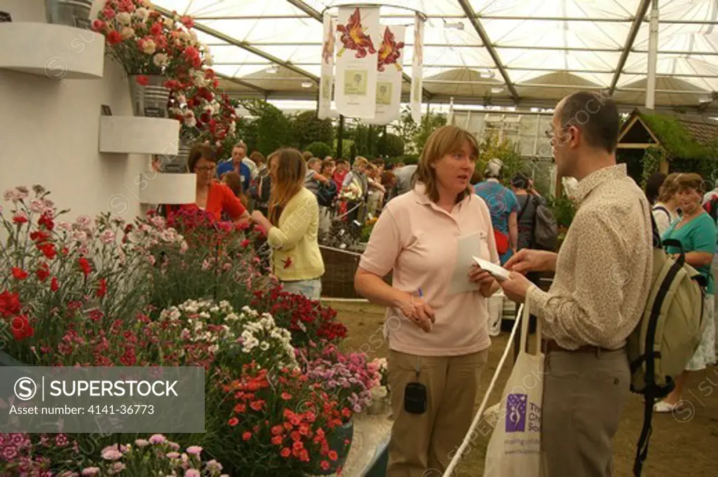 dianthus display featuring many named varieties and customer questioning staff member. whetman pinks, chelsea rhs flower show, london, england 2008. date: 22.10.2008 ref: zb1159_122662_0010 compulsory credit: photos horticultural/photoshot 