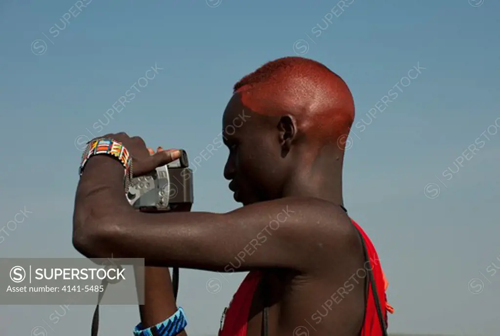 masai warrrior ( a moran ) using a video camera, kenya.