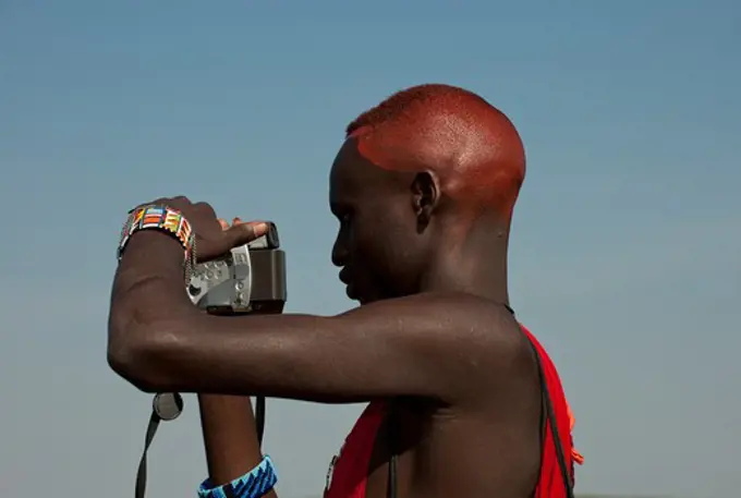 masai warrrior ( a moran ) using a video camera, kenya.